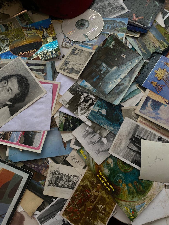 A flat lay of vintage photos, postcards, and CDs creating a nostalgic collection.